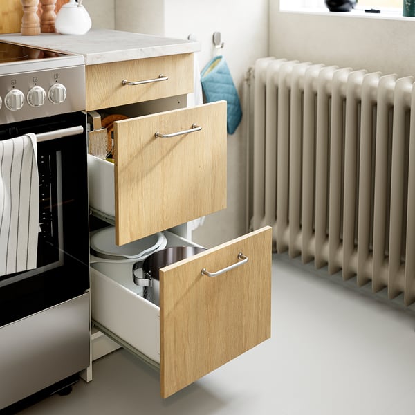 Kitchen cabinet with open drawers showing storage space and organisational compartments.