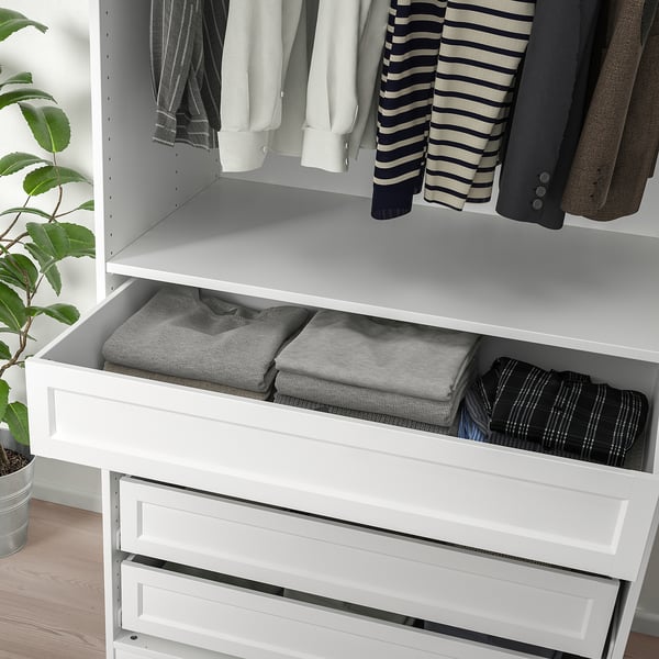 Wardrobe drawer with folded clothes, neatly organised with KOMPLEMENT boxes. Drawer glides silently and closes softly.