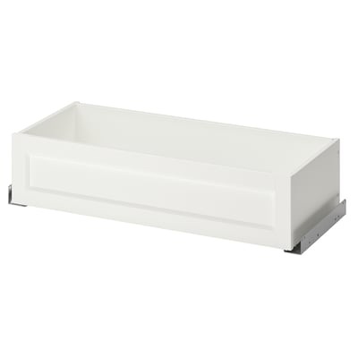 A white KOMPLEMENT wardrobe drawer with a sleek design, featuring a framed front, metal glides, and a clean, rectangular shape.