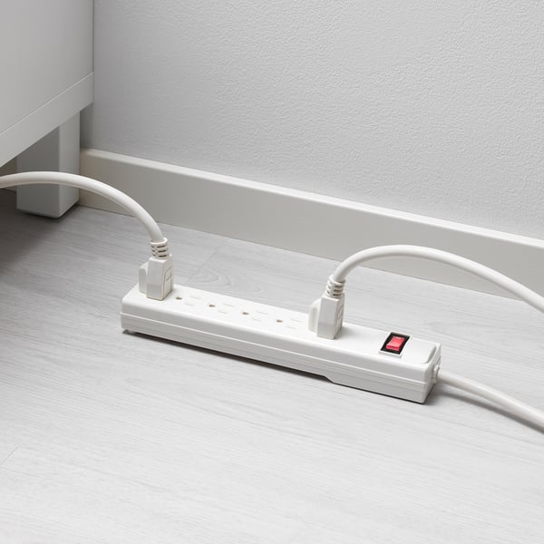 White surge protector on wooden floor.