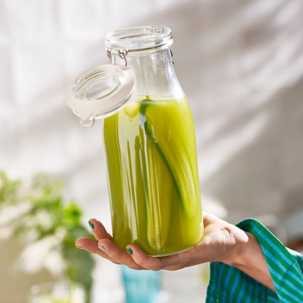 Hand holding KORKEN jar with pickles