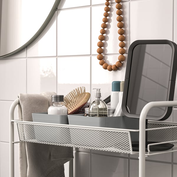 Metal rack with soap and hairbrush, mirror and tiles.
