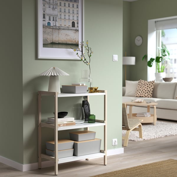Modern green living room with KUGGIS storage, lamp, plants, and sofa.