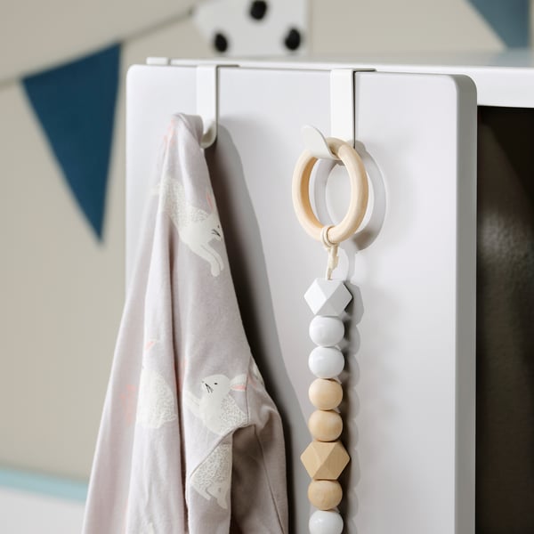 A white LÄTTHET hook with hanging blanket and wooden bead toy.