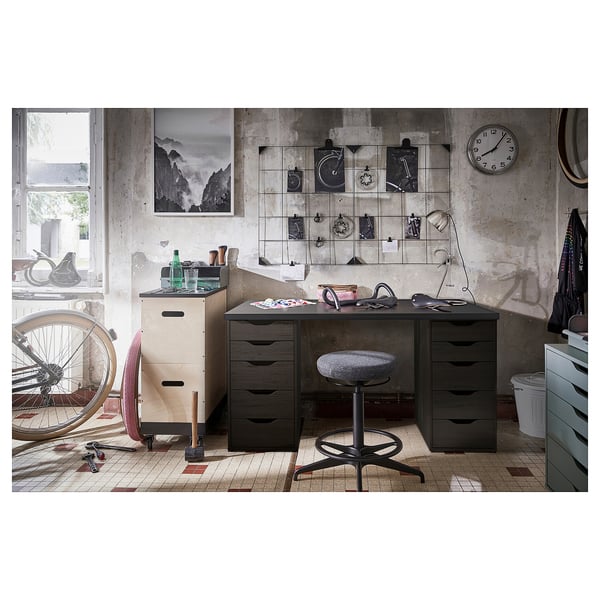 Industrial-themed work setup with LAGKAPTEN dark grey desk, swivel chair, and wall clock.