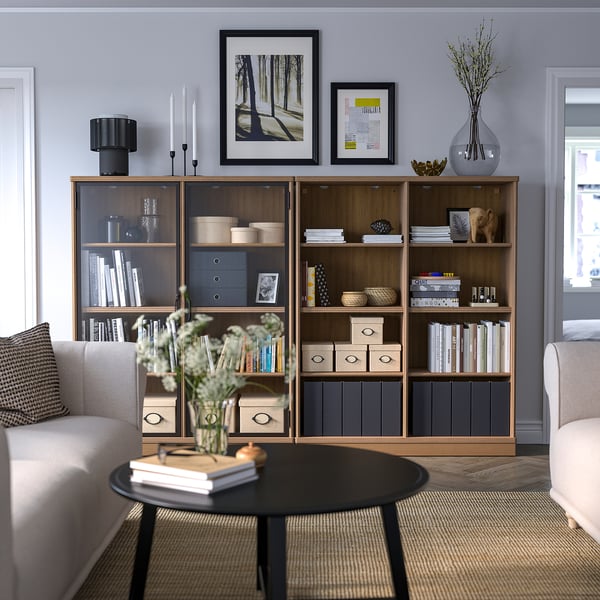 Modern living room with wooden bookcase, armchairs, coffee table.