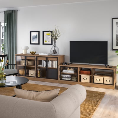 Modern living room with beige sofa, tv console, grey curtains, and art.