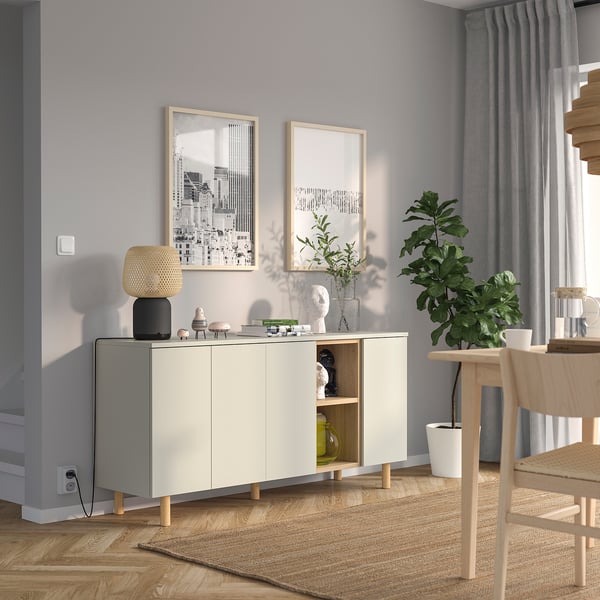 LEDAMOT white cabinet, narrow for small spaces, open shelves top, closed bottom compartments, between wall art, table, and curtains.