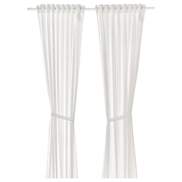 White polka-dot curtains with tiebacks, made of cotton.