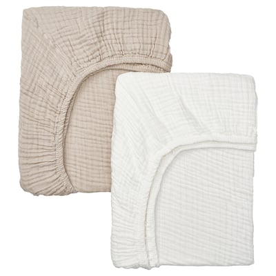 Beige & white bed sheets visible, beige slightly folded on top, both have elastic corners, light textured surface.
