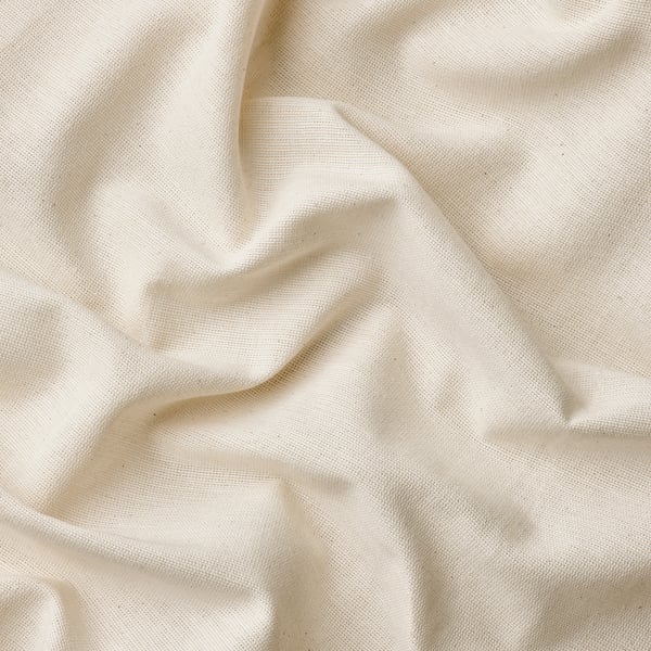 A close-up of soft, off-white cotton fabric with a subtle, linear weave, showcasing its smooth texture and quality curtain.