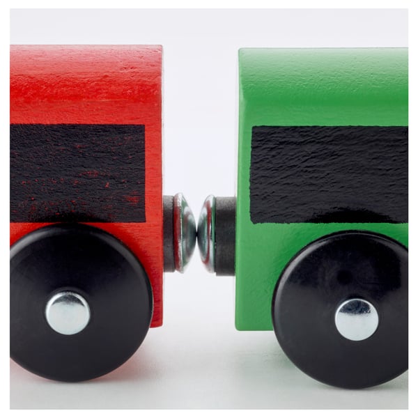 Two vibrant wooden toy train cars, red and green, linked by a metal connector, showcasing durable construction and vivid colours.