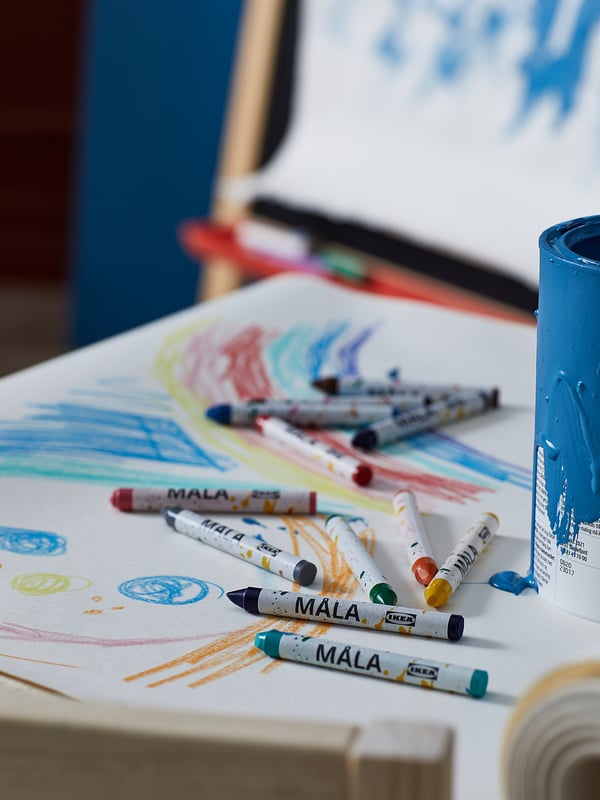 White and colourful MÅLA crayons on rolled paper for drawing.