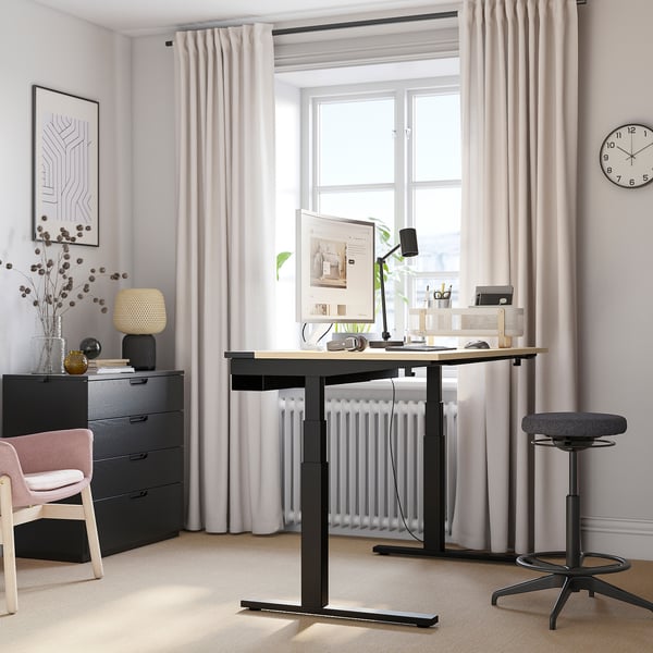 Home office: MITTZON black desk, computer monitor, black stool, chair, drawer, decor, window, lamp, plant.