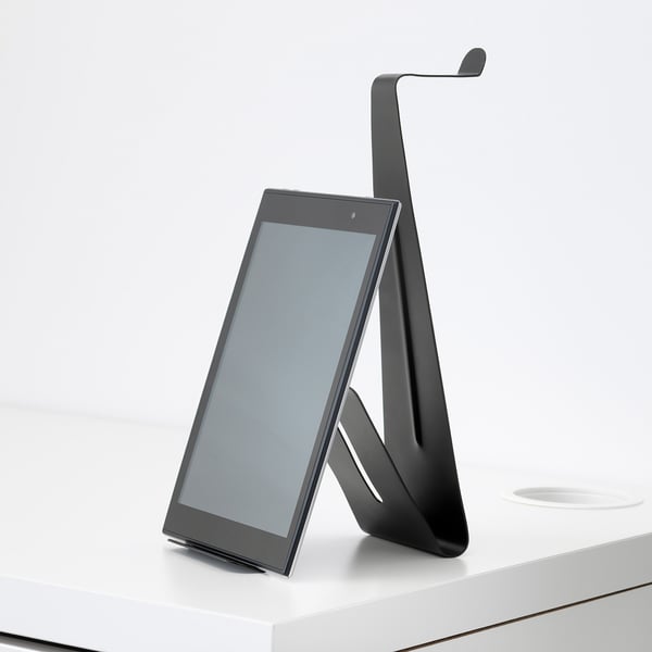 Modern tablet stand in black holding a tablet upright on a white desk.