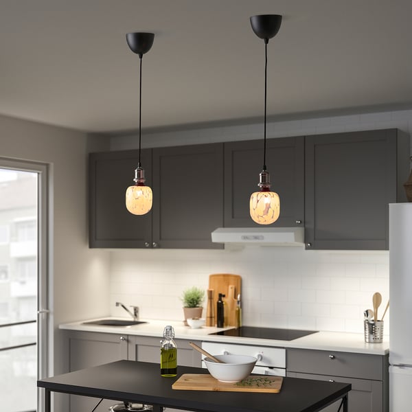 Two hanging MOLNART led bulbs illuminate kitchen island with cutting board.