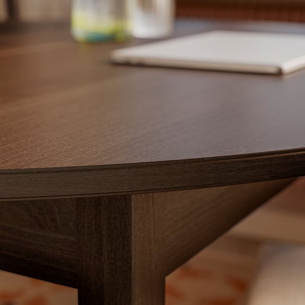 Close-up of a well-crafted wooden table with a smooth, dark finish and visible wood grain, showcasing its sturdy, chamfered legs.