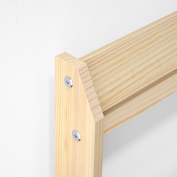 Close-up of sturdy wooden bed frame joint with screws; durable, natural pine wood.