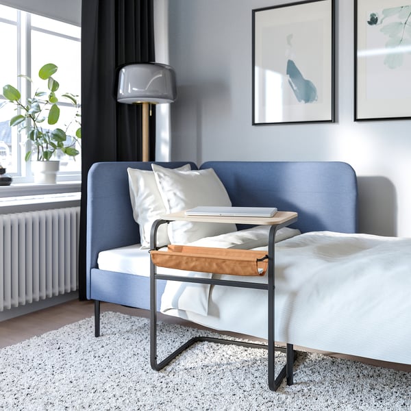 Modern bedroom with blue sofa and adjustable olse verko laptop table.