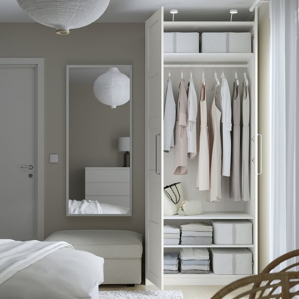 Modern bedroom with PAX wardrobe, mirror, and pendant light.