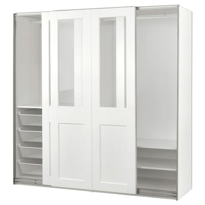 White PAX wardrobe with glass panels, sliding doors, shelves, and mesh baskets.