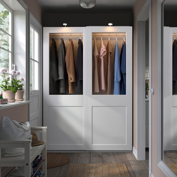 White PAX wardrobe with glass doors showing organised clothes.
