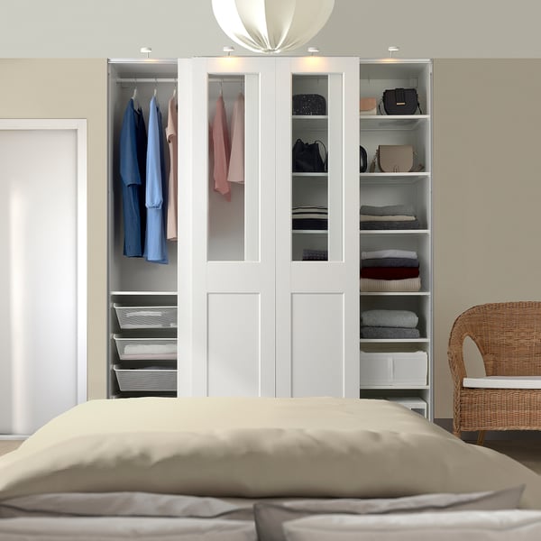 Modern bedroom with PAX wardrobe, bed, chair, and lamp.