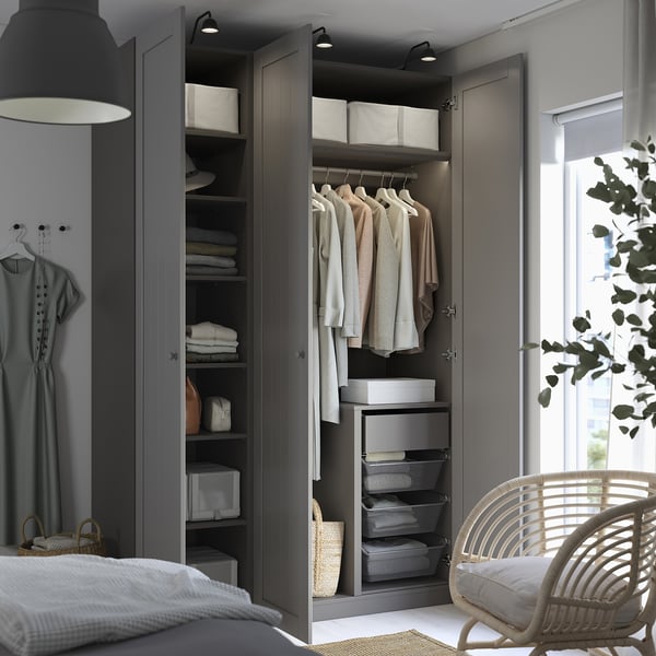 A modern wardrobe with open doors revealing shelves and hanging garments. The wardrobe has integrated lighting and mesh drawers for air circulation.