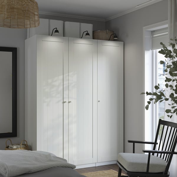 White PAX wardrobe by window, simple design, serene bedroom.