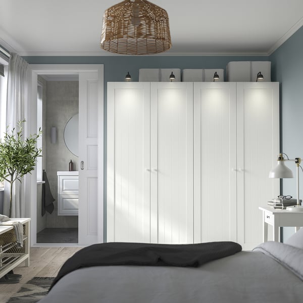 Modern bedroom with large white PAX closet, built-in lights, and grey bed sheets.
