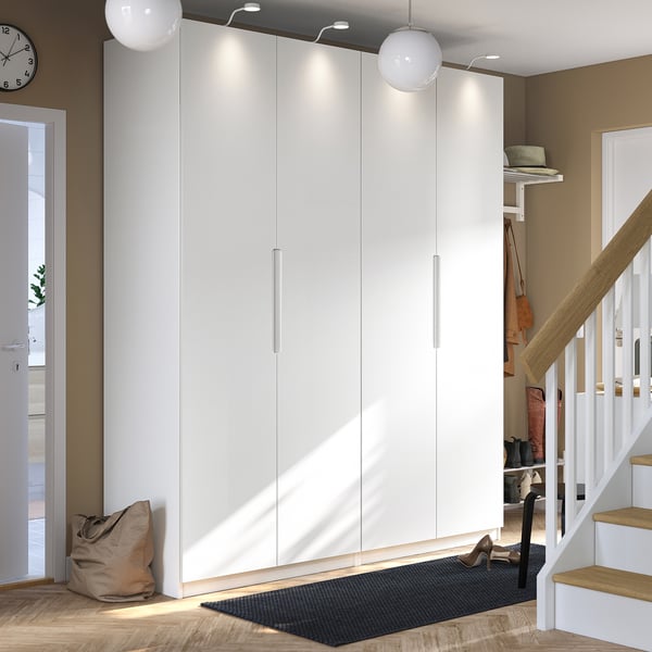Modern entryway with large white PAX wardrobe, sleek design, soft lighting, staircase, and shoe rack.