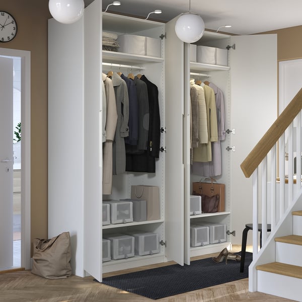 Modern closet with open doors displaying clothes, jackets, and storage boxes. Located near a staircase, featuring organised storage solutions.