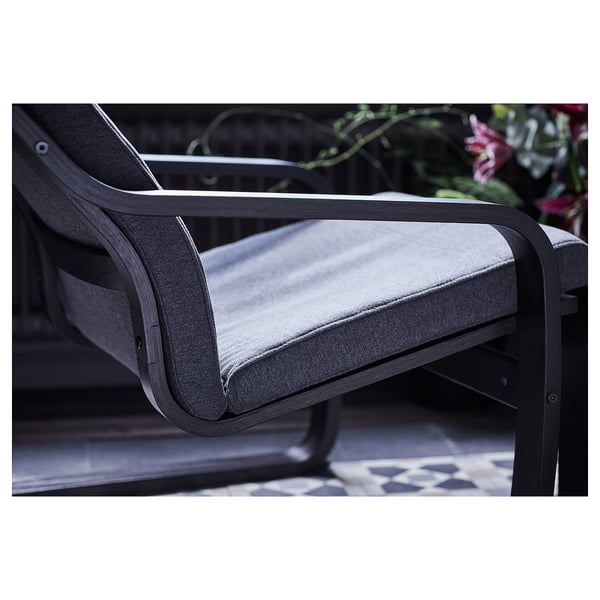Modern grey armchair with curved back, black metal frame, cushioned seat & back.