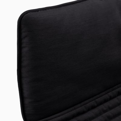 Black cushioned seat, likely from a chair, with neatly finished edges. The texture appears soft and inviting, suggesting comfort.