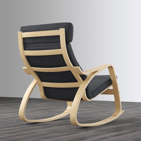 A light wooden rocking chair with dark cushions sits on a wooden floor, showcasing a comfortable and inviting design.