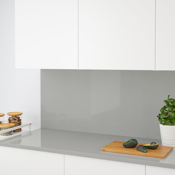 Modern kitchen with a sleek countertop, avocados and a plant.
