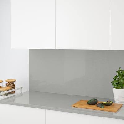 Modern kitchen with a sleek countertop, avocados and a plant.