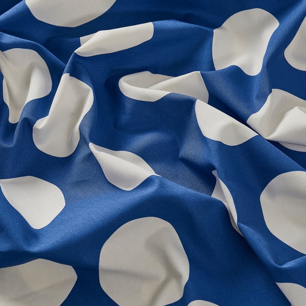 Image blue cotton fabric with white dotted pattern, neatly folded, showcasing high-quality, smooth texture.