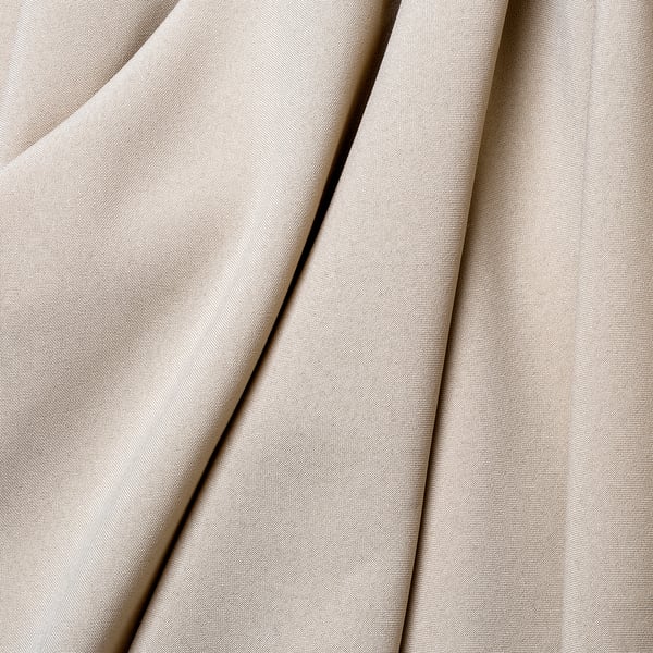Soft, beige curtains with small, orderly patterns, neatly draped, showcasing high-quality texture.