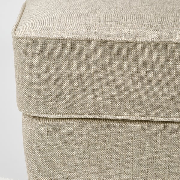 Close-up of soft, light grey ottoman with textured fabric, showing stitching and padding detail.
