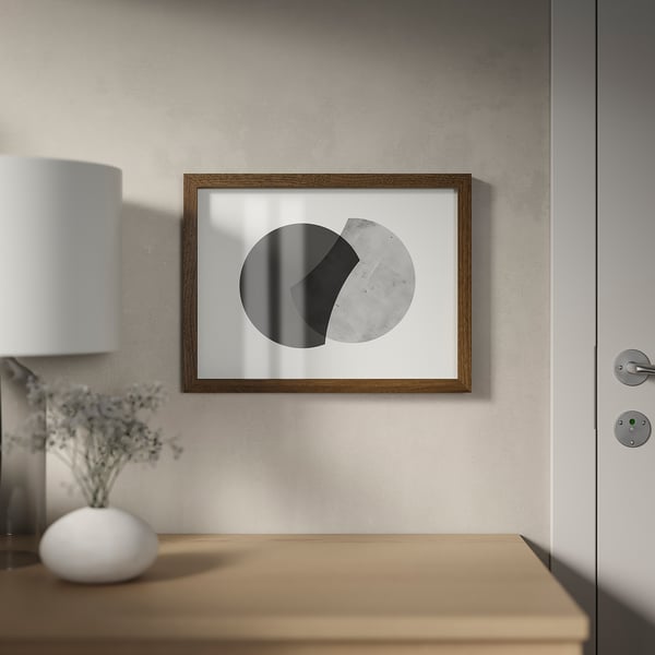Framed modern art on wall next to door; lamp and dried flowers on table.
