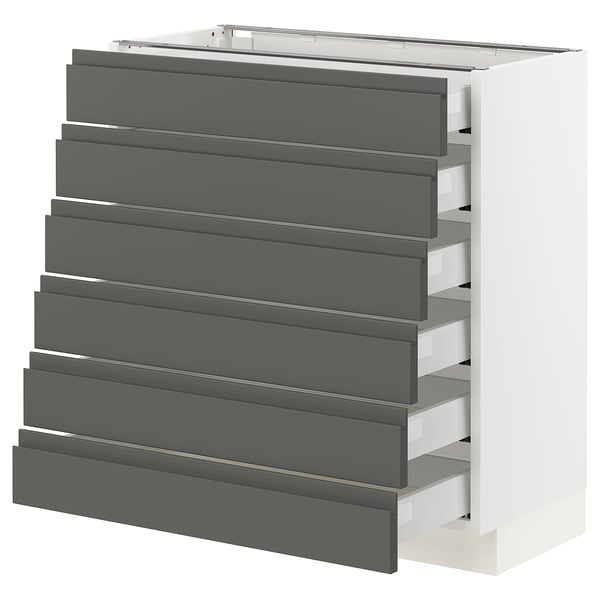 A modern white kitchen cabinet with eight dark grey drawers. The drawers have integrated handles and feature a sleek, contemporary design.