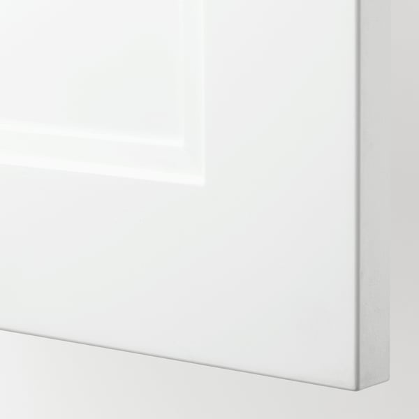 Close-up of a sleek, white cabinet door with smooth edges, part of the SEKTION kitchen system, highlighting its modern design and quality finish.