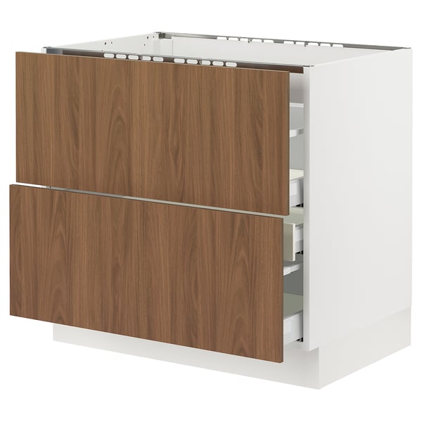 An ikea SEKTION kitchen cabinet with walnut-colored tistorp drawers. Its white and rectangular with smooth surfaces and modern design.