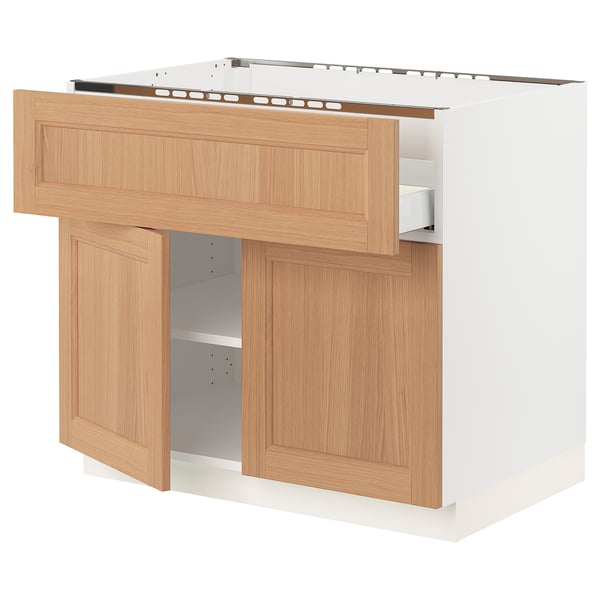 A SEKTION kitchen unit in white with oak doors. The unit has open shelving and drawers.