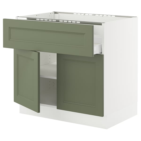 Modern olive green kitchen cabinet with white interior, open doors, and adjustable shelf.