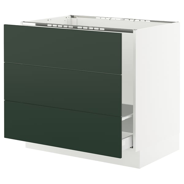 Modern green kitchen cabinet with three drawers and white trim.