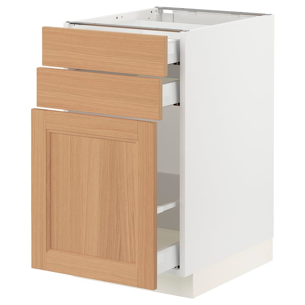 A white SEKTION kitchen cabinet with oak wood drawers and door. It three drawers and one large door, designed for kitchen storage.