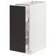 A white SEKTION kitchen cabinet with a black nickebo door, featuring a pull-out mechanism and sleek, modern design.