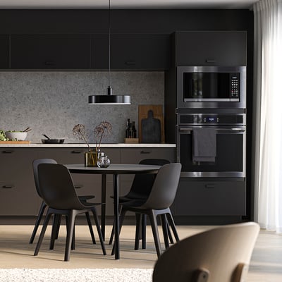 Modern kitchen with black SEKTION cabinets, chairs, and appliances; light countertop and backsplash.